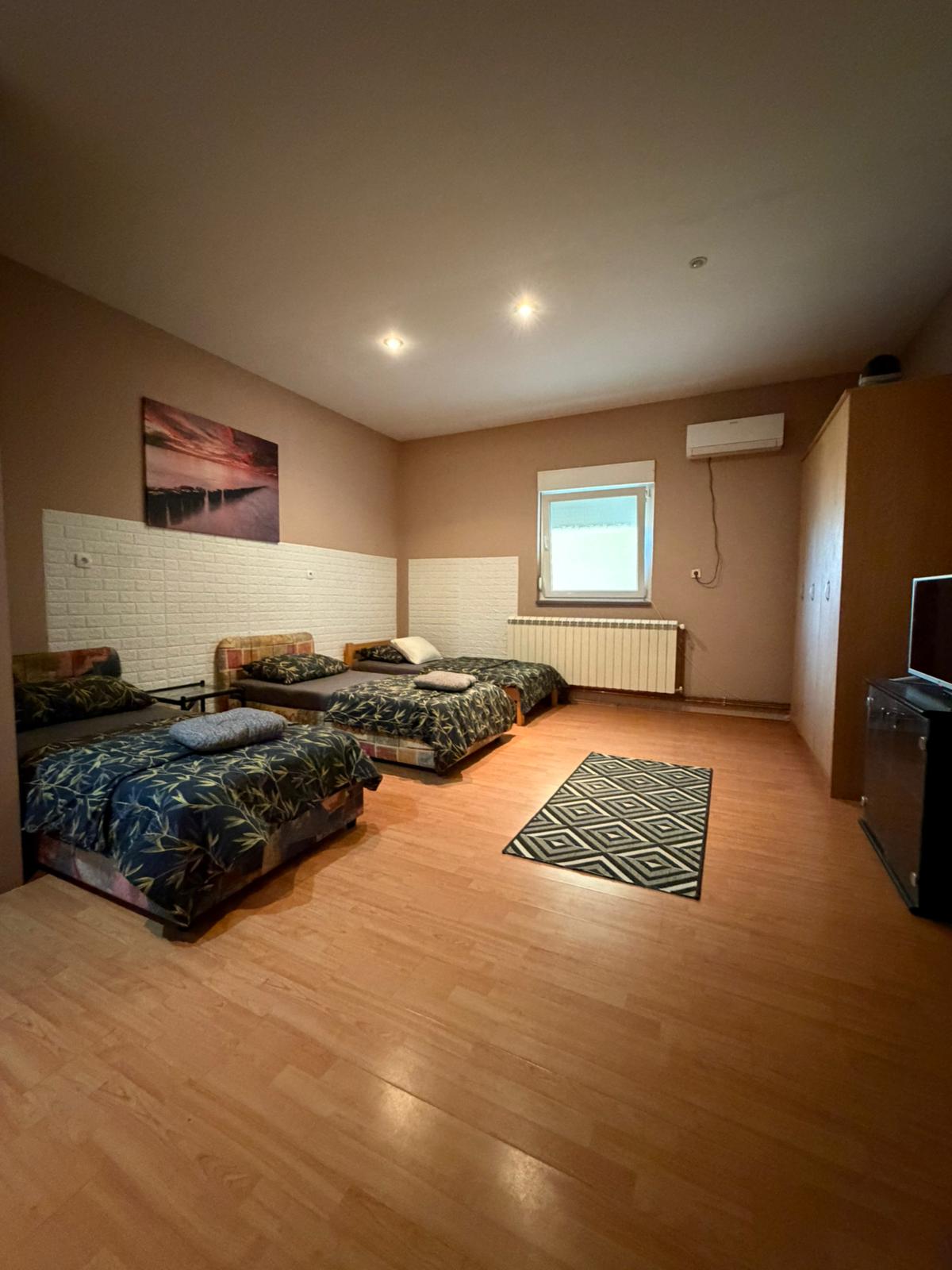 Soba sa tri kreveta i tepihom