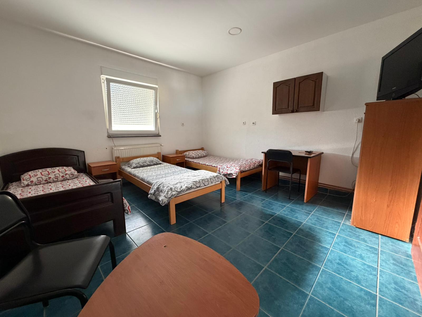 Soba sa tri kreveta i ljubičastim pokrivačima